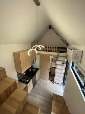 a small kitchen with wooden cabinets and a staircase at Mini Casa en Poblado Medellín FRN109 By Roots Rentals in Medellín