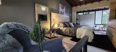 a bedroom with a bed and a living room at Luxury Loft Shakespeare in Medellín