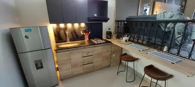 a kitchen with a refrigerator and a counter with stools at Luxury Loft Shakespeare in Medellín