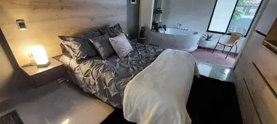 a bedroom with a bed and a bathroom with a tub at Luxury Loft Shakespeare in Medellín