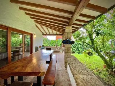 a wooden table in a living room with a large window at Luxury Villa In Provenza in Medellín