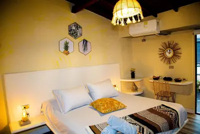 a bedroom with a bed and a chandelier at Casa Jiwa In Provenza in Medellín