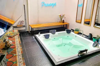 a large bath tub in a room with a bench at Casa Jiwa In Provenza in Medellín