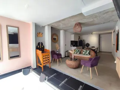a living room with purple chairs and a couch at Casa Jiwa In Provenza in Medellín