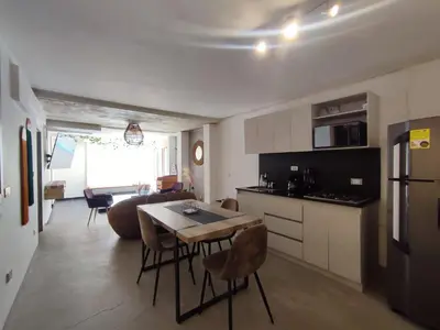 a kitchen and living room with a table and chairs at Casa Jiwa In Provenza in Medellín