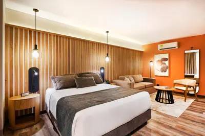 a hotel room with a bed and a couch at Blues Suites Medellín in Medellín