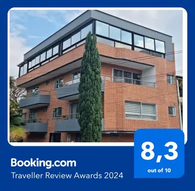 a brick building with a tree in front of it at Amplio y acogedor Apartamento Sabaneta. in Sabaneta