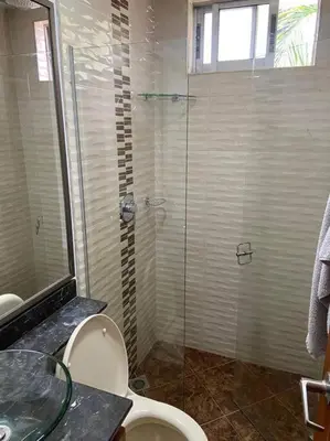 a bathroom with a glass shower and a toilet at Amplio y acogedor Apartamento Sabaneta. in Sabaneta