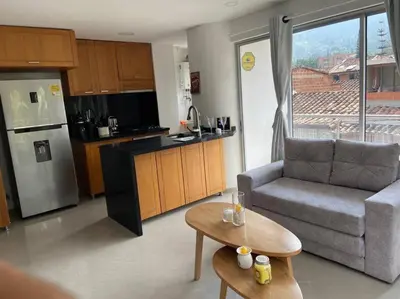 a kitchen and living room with a couch and a table at Amplio y acogedor Apartamento Sabaneta. in Sabaneta