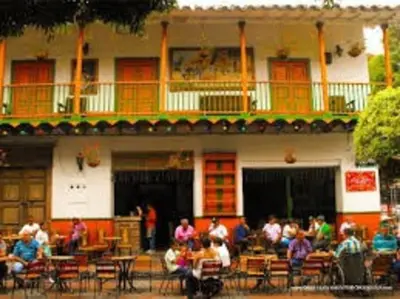 a group of people sitting at tables in front of a building at Amplio y acogedor Apartamento Sabaneta. in Sabaneta