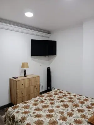 a bedroom with a bed and a flat screen tv at Medellin apartamento en laureles in Medellín