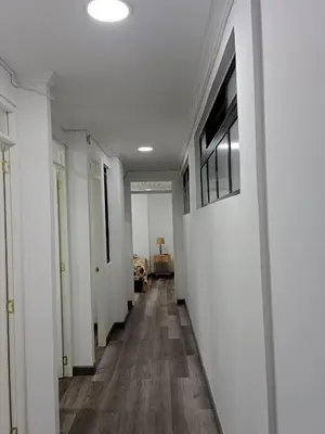 a long hallway with white walls and wood floors at Medellin apartamento en laureles in Medellín