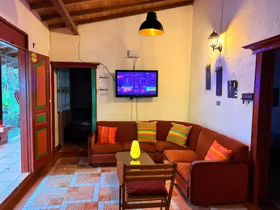a living room with a couch and a tv at Maravilla de cabaña grupal 5-10 personas parking, wifi, campestre, cercana in Jardin