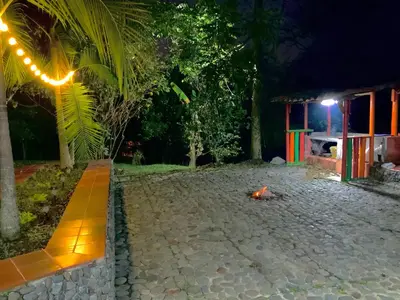 a courtyard at night with a fire in the middle at Maravilla de cabaña grupal 5-10 personas parking, wifi, campestre, cercana in Jardin