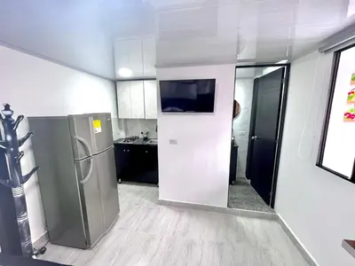 a kitchen with a refrigerator and a tv on the wall at Edificio SantaMarta Medellín in Medellín