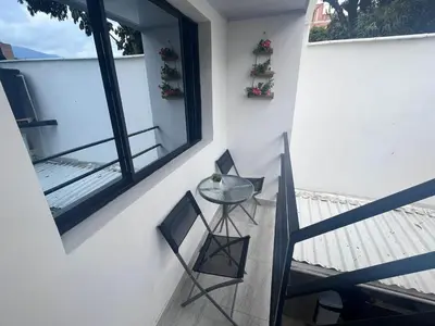 a balcony with a glass table and two chairs at Edificio SantaMarta Medellín in Medellín