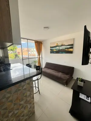 a kitchen and a living room with a couch at Amplio ApartaStudio en Boston in Medellín