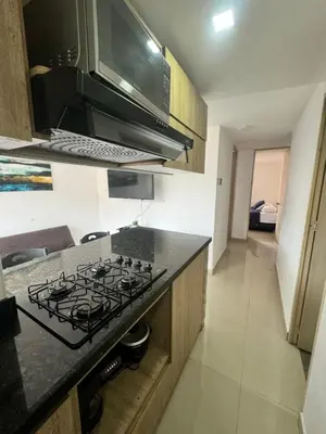 a kitchen with a stove and a microwave at Amplio ApartaStudio en Boston in Medellín