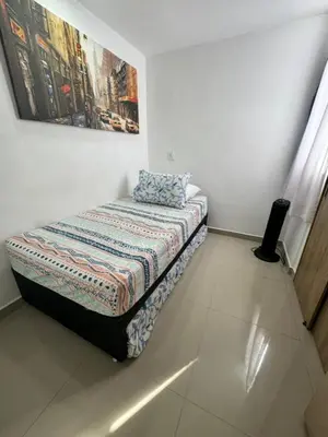 a bed in a room with a painting on the wall at Amplio ApartaStudio en Boston in Medellín