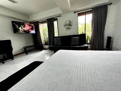 a bedroom with a bed and a flat screen tv at ApartaStudio El Poblado in Medellín