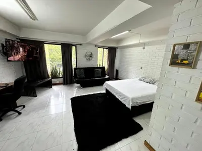 a bedroom with a bed and a couch in a room at ApartaStudio El Poblado in Medellín
