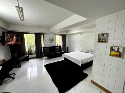 a bedroom with a bed and a couch in a room at ApartaStudio El Poblado in Medellín