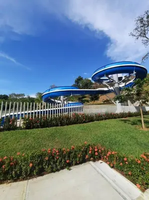 a blue roller coaster in a park with a fence at Citadela Di Sole - Apartamento in Santa Fe de Antioquia