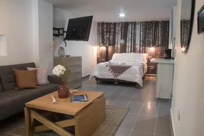 a living room with a bed and a coffee table at Espectacular apartaestudio en sabaneta! in Sabaneta