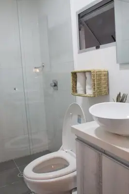 a white bathroom with a toilet and a sink at Espectacular apartaestudio en sabaneta! in Sabaneta