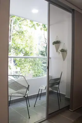 a glass door with a chair and a window at Espectacular apartaestudio en sabaneta! in Sabaneta