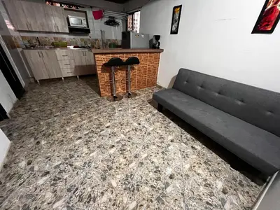 a living room with a couch and a counter at Aparta Suite Torre De Prado 303 in Medellín