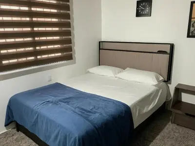 a bedroom with a bed with a blue blanket on it at Aparta Suite Torre De Prado 303 in Medellín