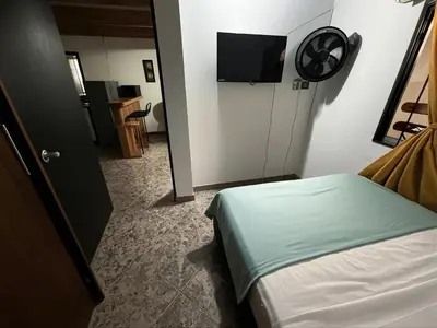 a bedroom with a bed and a flat screen tv at Aparta Suite Torre De Prado 303 in Medellín