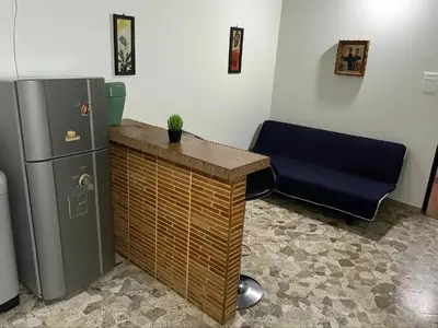 an office with a desk and a refrigerator and a chair at Aparta Suite Torre De Prado 303 in Medellín