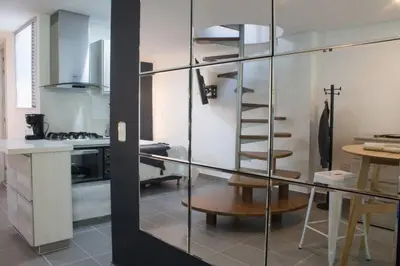 a kitchen with a glass wall with a spiral staircase at Espectacular apartamento Duplex VIP 501 con jacuzzy in Sabaneta