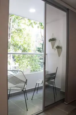 a glass door with a chair and a window at Espectacular apartamento Duplex VIP 501 con jacuzzy in Sabaneta