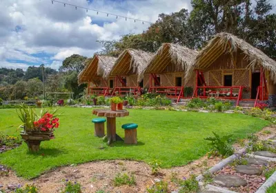 a group of huts in a field with a garden at Jardin de los Silleteros Agro Parque Hotel in Santa Elena