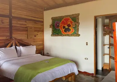 a bedroom with a bed and a painting on the wall at Jardin de los Silleteros Agro Parque Hotel in Santa Elena