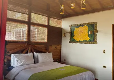 a bedroom with a bed and a painting on the wall at Jardin de los Silleteros Agro Parque Hotel in Santa Elena