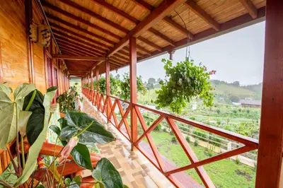 a room with a balcony with a view of a vineyard at Jardin de los Silleteros Agro Parque Hotel in Santa Elena