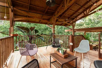 a wooden deck with chairs and a table at Tominejo Ecolodge - Casas en los árboles in Neira