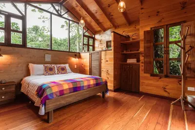 a bedroom with a bed in a log cabin at Tominejo Ecolodge - Casas en los árboles in Neira