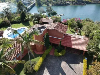 an aerial view of a house next to the water at Finca El paraíso Guatape in Guatapé