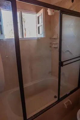a shower with a glass door in a bathroom at Finca El paraíso Guatape in Guatapé
