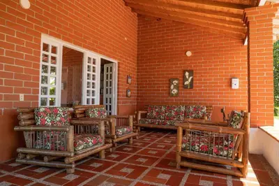 a porch with couches and a brick wall at Finca El paraíso Guatape in Guatapé