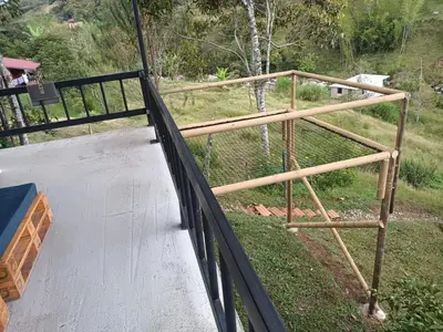 a wooden railing on a balcony with a giraffe at Hospedajes el Jardin cabaña in Concepción