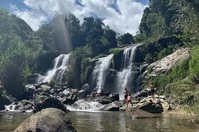 a group of people standing in front of a waterfall at Hospedajes el Jardin cabaña in Concepción