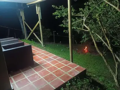 a brick walkway with a fire in a backyard at night at Hospedajes el Jardin cabaña in Concepción