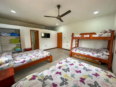 a bedroom with two bunk beds and a fan at Parcela la cascada in Doradal