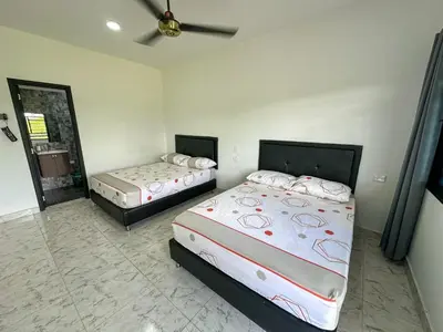 a bedroom with two beds and a ceiling fan at Parcela la cascada in Doradal